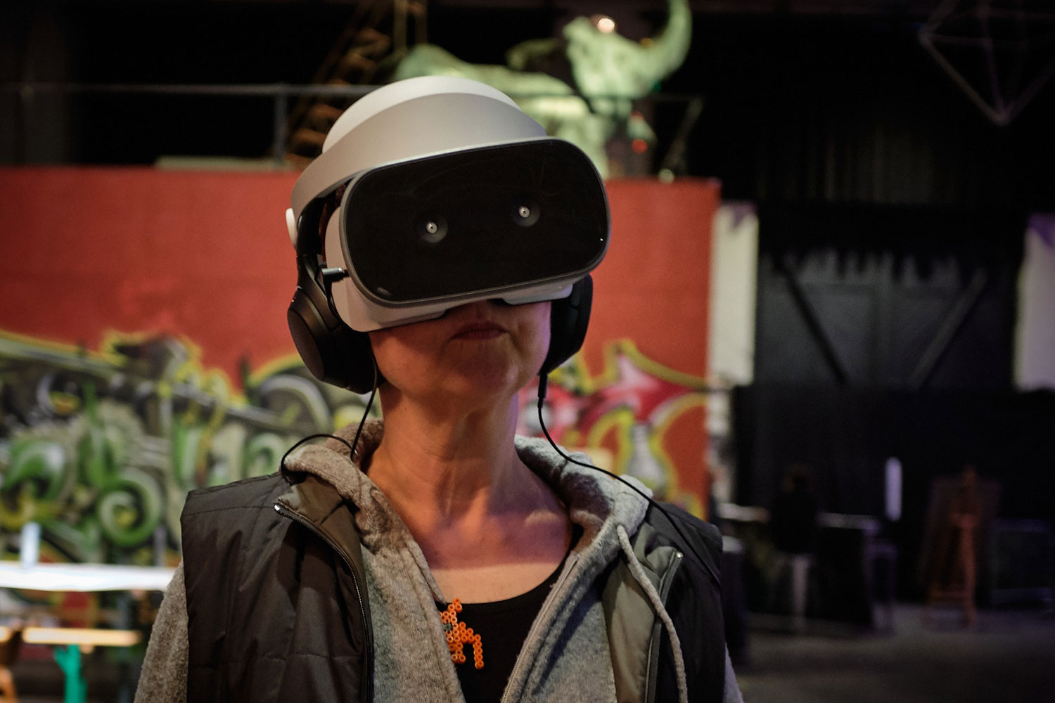 Foto-Portrait einer Frau mit Helm, Kopfhörern und einer grossen dunklen Brille.